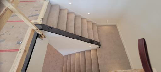 Gorgeous craftsman-styled open staircase with sophisticated wooden railing (installing soon), extra-wide width, turned safety landing, and lovely step lighting.