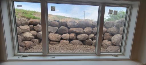 This custom boulder wall enhancement really showcases the stunning view of the country sky instead of an ordinary single egress window.