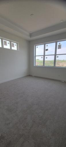 Relaxing owner's retreat with generous proportions for a reading nook, showcase beautiful open-sky views, a lofty box ceiling accent and abundant natural lighting.