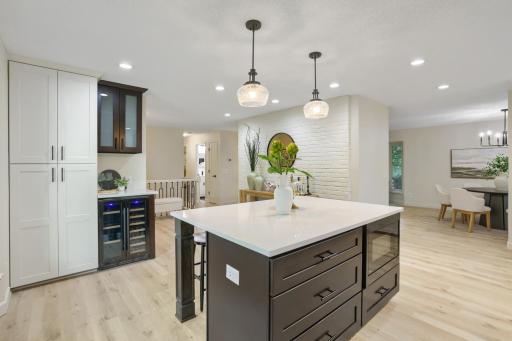 The open-concept design flows seamlessly into the surrounding living spaces, while expansive work surfaces and generous cabinetry provide exceptional functionality for everyday living and entertaining.