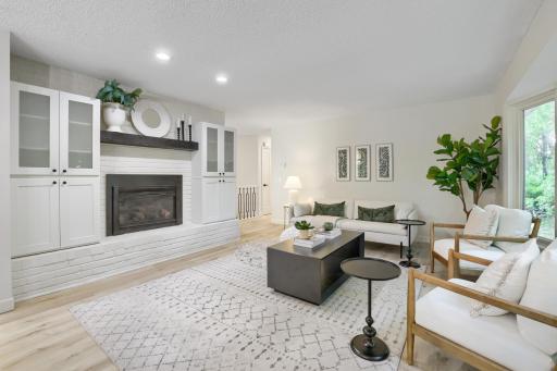 The gas fireplace serves as the focal point of the space, enhanced by a substantial custom wood mantel and expansive hearth that adds both character & functionality. Designed for both everyday comfort and effortless entertaining,