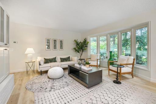 A large bay window fills the room with natural light while providing picturesque views of the mature landscaping outside, creating a bright and airy feel throughout the day. Fresh neutral finishes,& updated lighting complement the home's design