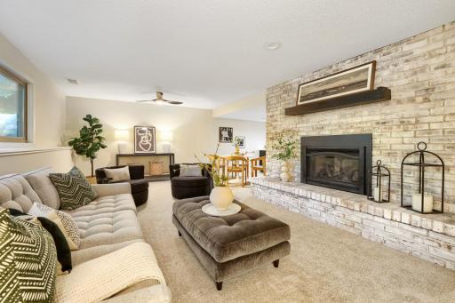 Anchored by a stunning floor-to-ceiling whitewashed brick fireplace with a gas insert and substantial wood mantel, this room serves as the perfect gathering place for family and friends.