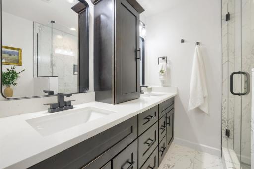 The luxurious primary ensuite bathroom has been completely transformed into a spa-inspired retreat. A custom built-in storage tower provides exceptional organization and abundant space for linens, toiletries, and everyday essentials