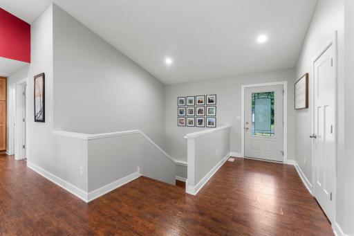 The welcoming entry highlights the warm wood LVP flooring. A coat closet is conveniently located just steps from the main door.