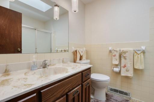 Upper level full tiled bath with newer skylight to let the natural sunlight inside.
