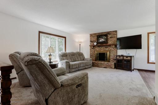 Upper level Living Room with gas fireplace. New carpet and fresh paint. Vinyl windows have been updated over the years. Add your own window treatments.