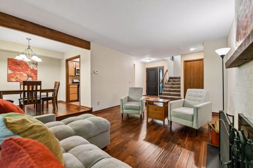 18x12 Main Floor Living room with Hardwood floors, Fireplace and north-facing windows opening up to the wooded back patio.