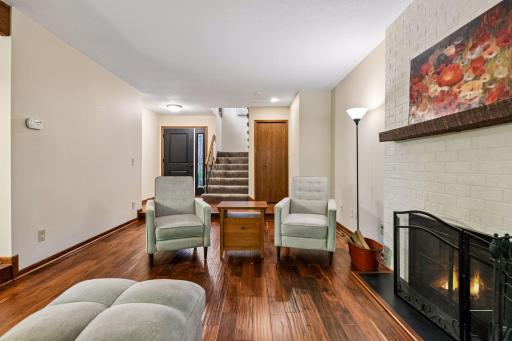 18x12 Main Floor Living room with Hardwood floors, Fireplace and north-facing windows opening up to the wooded back patio.