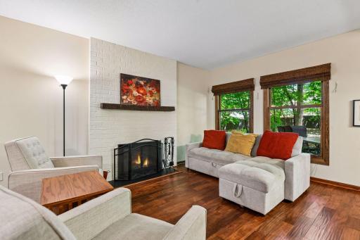 18x12 Main Floor Living room with Hardwood floors, Fireplace and north-facing windows opening up to the wooded back patio.