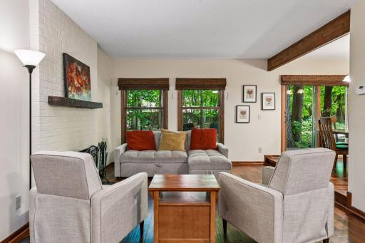18x12 Main Floor Living room with Hardwood floors, Fireplace and north-facing windows opening up to the wooded back patio.