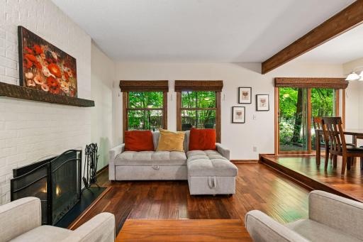 18x12 Main Floor Living room with Hardwood floors, Fireplace and north-facing windows opening up to the wooded back patio.