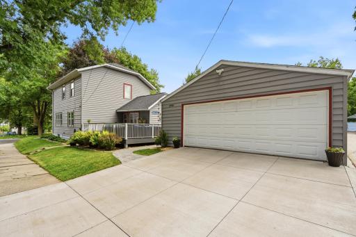 A new concrete driveway and paver walkway connect to the oversized 2 car garage.