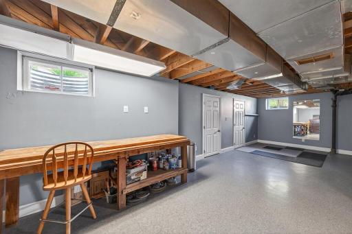 Unfinished section of basement with workbench. Could be finished off or used as a workout space or extra storage.