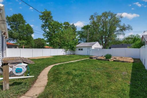 Large flat backyard is fully fenced in with vinyl privacy fence.