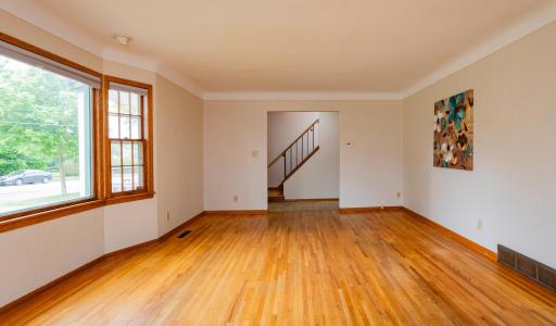 Huge living room with gleaming hardwood plus cove ceilings.jpg