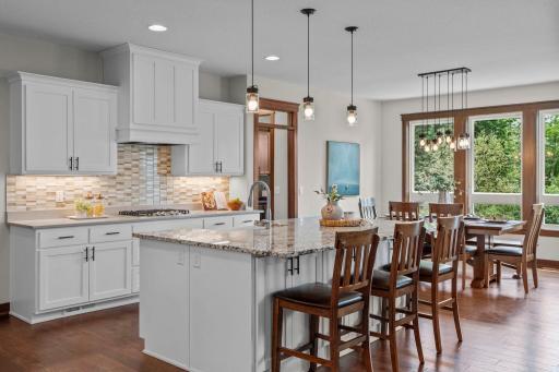 Solid wood cabinets and floor, soft close drawers and glass tile backsplash. The large center island can comfortably seat at least 5 while leaving plenty of room in the adjoining dining area. Perfect for hosting the holidays and entertaining friends.