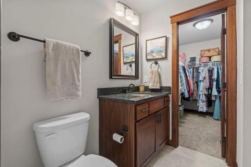 This second primary bath has a single sink vanity with tub/shower. The high quality finishes continue with solid wood cabinets, granite counter and tile floor. Another generous-sized walk-in closet.