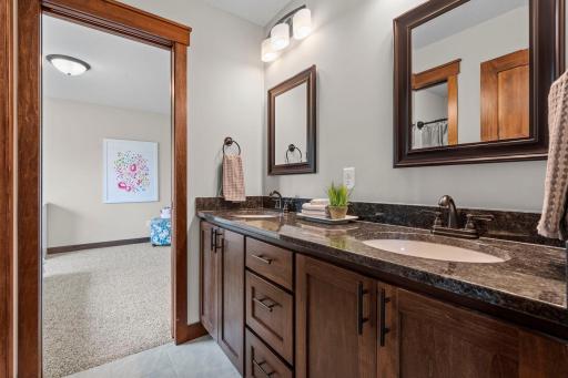 Large "Jack-and-Jill" full bathroom with dual sinks, granite counters and tile floors. A.s well as a shower/tub that has a pocket door for added privacy