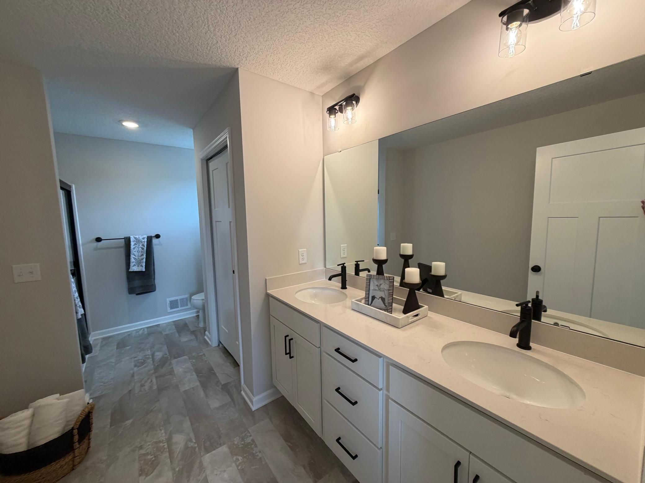 Dual vanity in the private en-suite bath provides maximum functionality. Features a large shower.