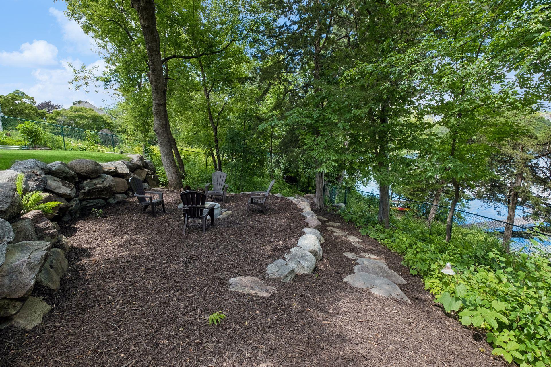 Firepit, path down to lake and dock visible in background.