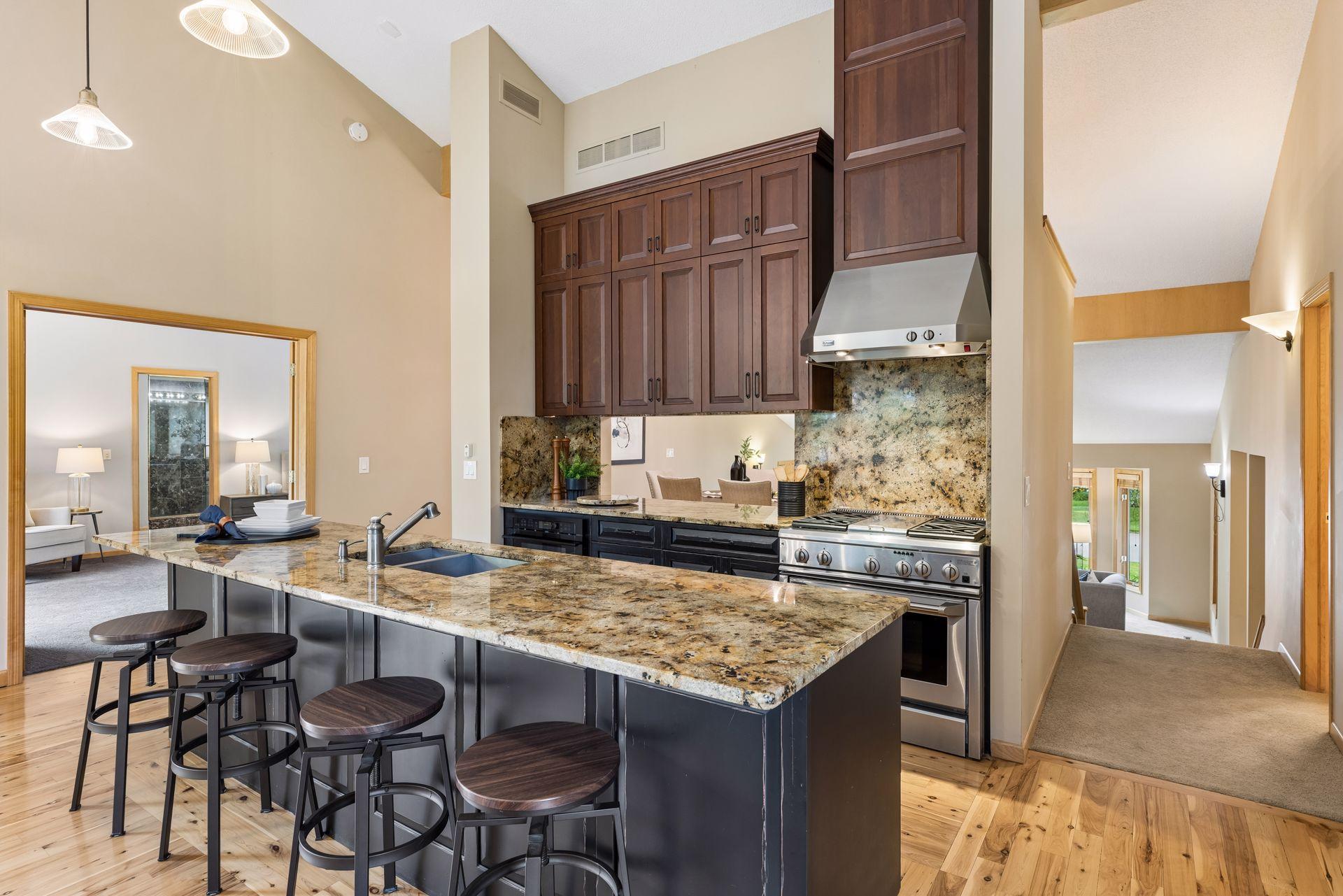 Updated kitchen with granite countertops, stainless appliances, open cutout to second dining area, center island with sink and breakfast bar seating. Through the French doors to the left is the primary suite.