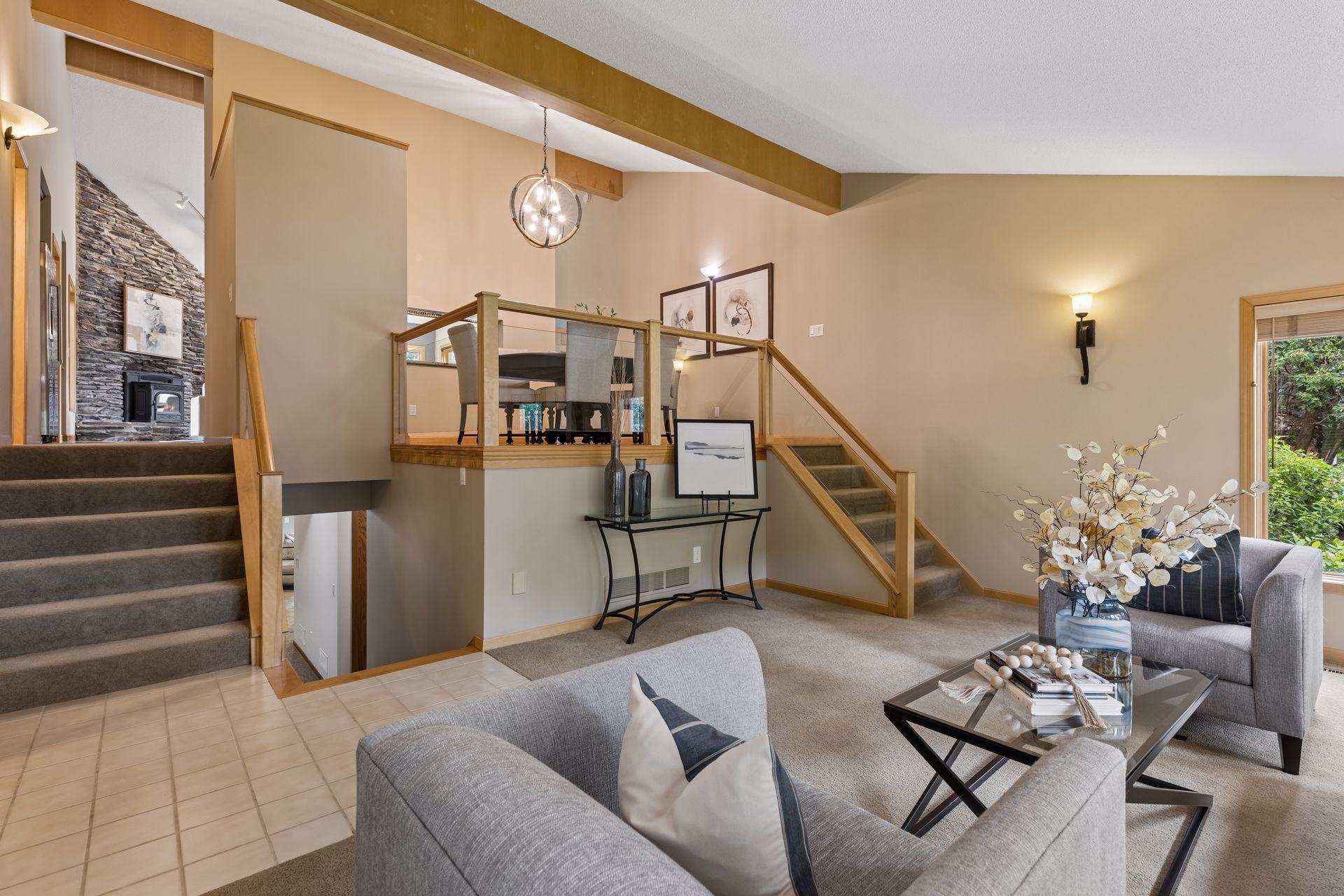 From living room, just short six steps up to great room areas and primary suite. Modern glass railings, open layout make this home stand out from the others.