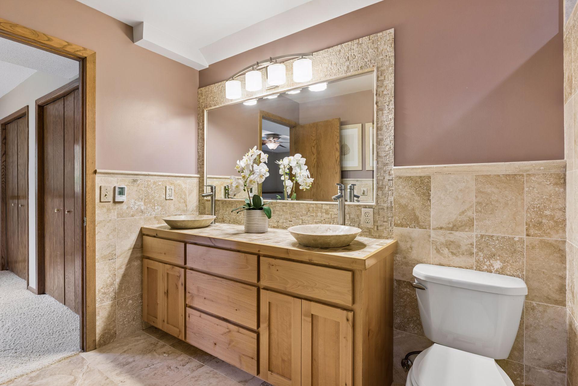 Lower level bathroom with heated Travertine tiled floors, dual sinks and walk-in shower.