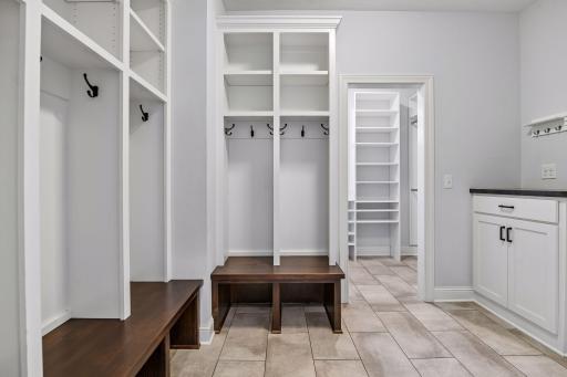 Mud room organized with cubbies, drop station and large closet