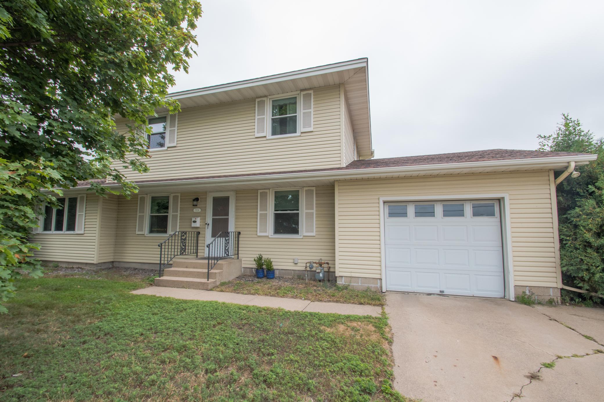 Front view shows the maintenance-free siding and additional parking on the concrete side parking pad