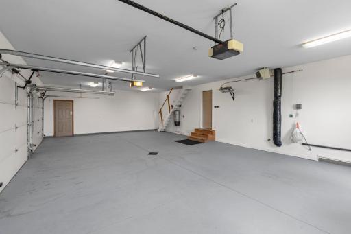Adjacent to the laundry room is access to the attached, finished, and heated three-car garage, which also includes attic access for additional storage.