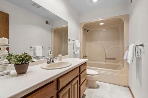 The main-level shared full bathroom features a single vanity with ample counter space and storage, along with a tub/shower combination.