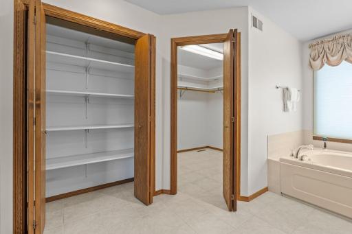 A view of the ensuite bathroom's large linen closet and spacious walk-in closet.