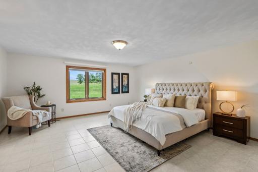 The spacious main-level primary bedroom features premium Italian tile flooring and a private en-suite bath designed for comfort and relaxation.