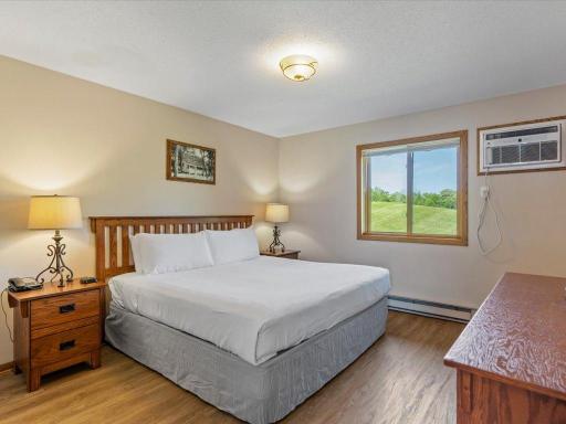 The main floor bedroom is very generous in size with LVP flooring, a window looking out towards the golf course and a newer window a/c unit.