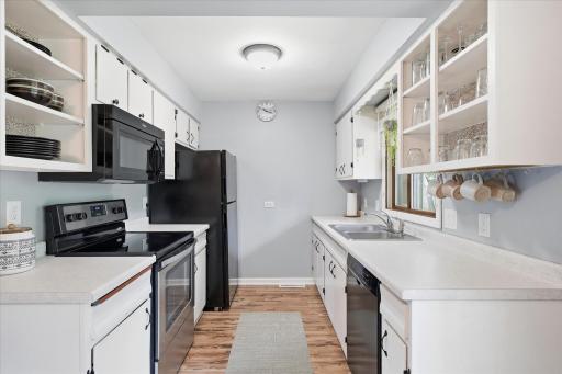 The efficient galley-style kitchen offers ample cabinetry, generous counter space, and a functional layout designed to maximize storage and workspace. Bright finishes create a clean and inviting atmosphere.