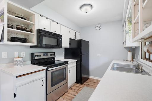 Featuring abundant cabinetry, open shelving, and a practical layout, this bright kitchen combines efficiency and style while offering excellent views of the backyard.