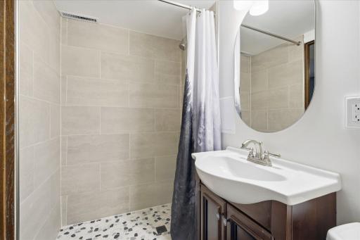 New lower level bathroom with walk-in tiled shower and contemporary finishes.