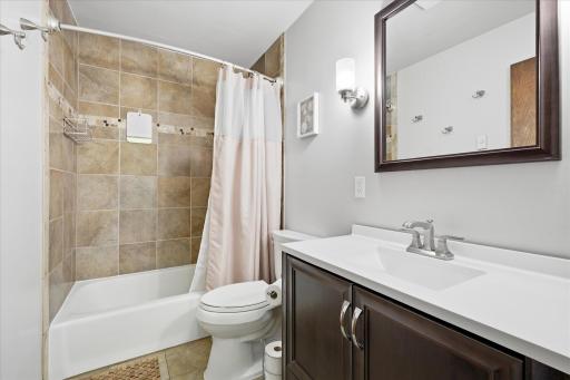 The updated full bathroom features a modern vanity, stylish fixtures, and a beautifully tiled tub surround. Clean lines and contemporary finishes create a fresh, move-in-ready space.