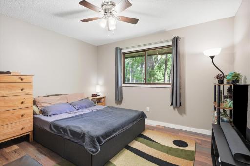 Second bedroom with fan offers views to the expansive backyard.