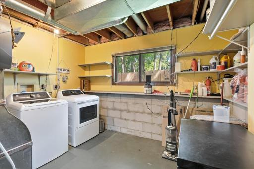 Large laundry room with shelving for extra storage on the lower level.