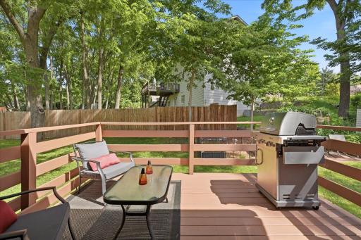 Step outside to enjoy a spacious, freshly stained, backyard deck overlooking the expansive yard and mature landscaping. The home's attractive rear elevation blends seamlessly into the peaceful natural surroundings.