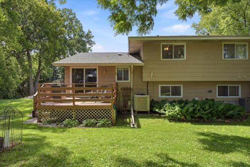 The backyard offers exceptional outdoor living space with a large deck, mature trees, and a beautifully maintained lawn. This private setting provides the perfect backdrop for relaxation and entertaining.