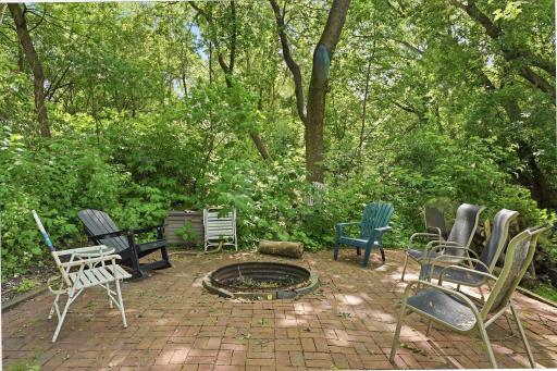 Tucked away at the end of culdesac is the inviting fire pit patio. Mature trees for added privacy and ambiance. This peaceful outdoor retreat is ideal for evening fires, entertaining guests, or relaxing under the canopy of nature.