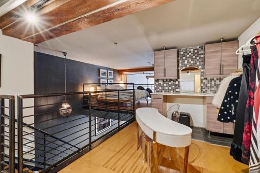 Upper-Level Loft Overlooking Main Living Space, open closet, desk or vanity area with storage