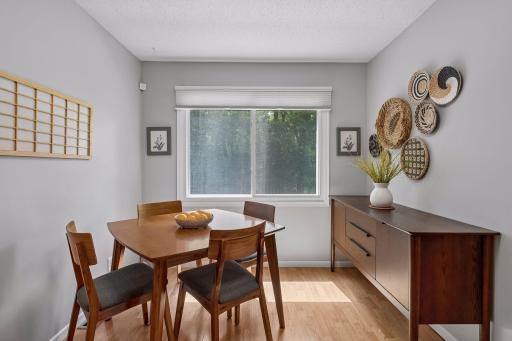 Sunlight pours into this inviting dining space, creating the perfect setting for everyday meals and special gatherings while offering peaceful views of the surrounding greenery.