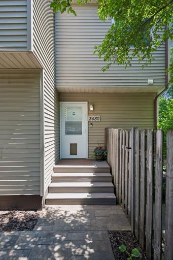 A very welcoming entryway to this home with composite steps and a stamped concrete patio.