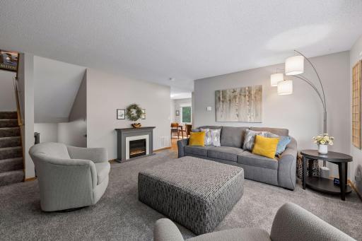 The inviting living room offers the perfect blend of comfort and style, featuring plush newer carpeting, fresh neutral dÃ©cor, and abundant natural light. The open flow to the dining area enhances both everyday living and entertaining,