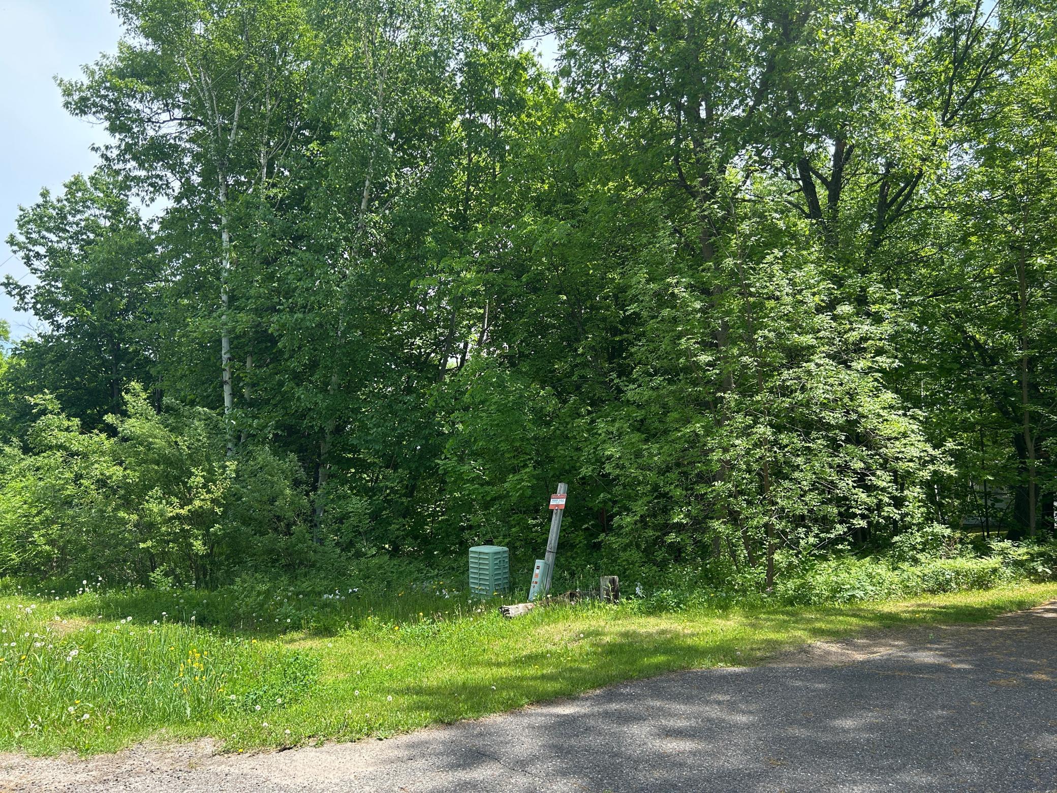 A view from the edge of the road. This is the neighbors driveway coming in, and this neighbor has a 16 foot easement that crosses the edge of this property allowing them access to their property.