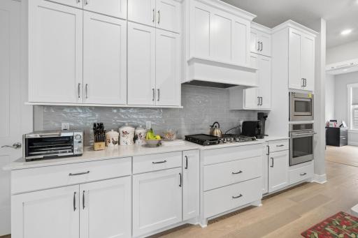 A kitchen designed with a full wall of cabinets creates a seamless, highly functional backdrop that maximizes both storage and visual impact. Floor-to-ceiling cabinetry spans the entire wall, offering a clean, built-in look that anchors the space.